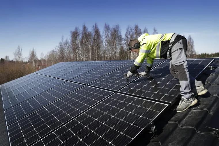 Installatör monterar solcellspaneler på ett hustak