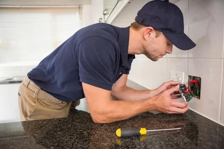 Elektriker monterar ett eluttag ovanför köksbänken