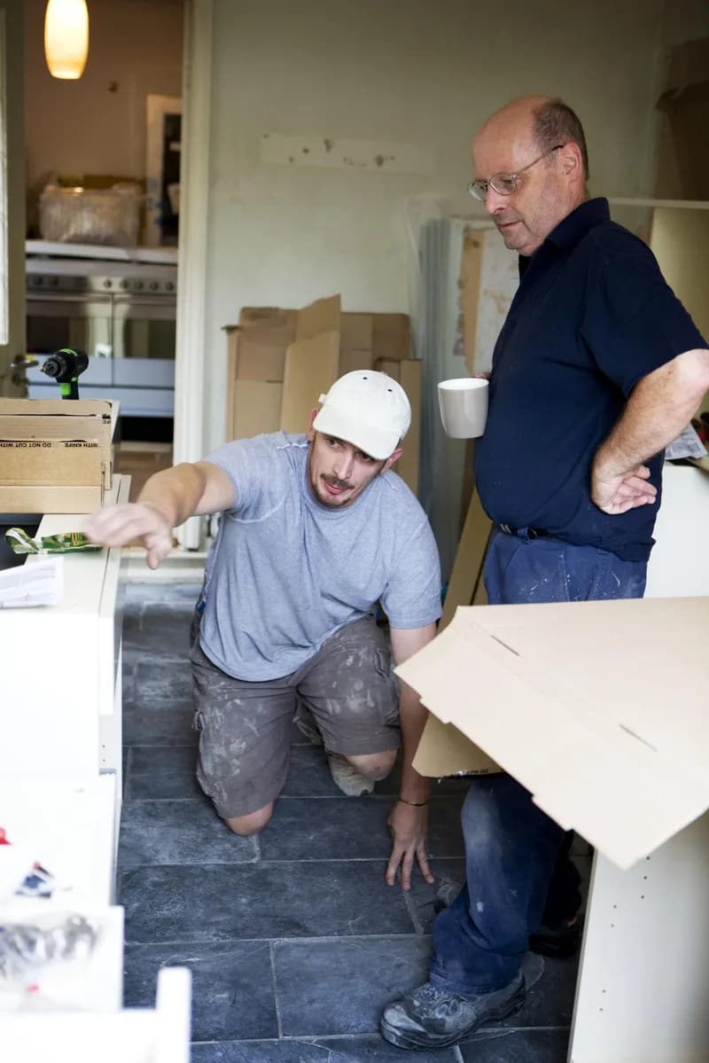 Hantverkare mäter och planerar köksskåp på plats