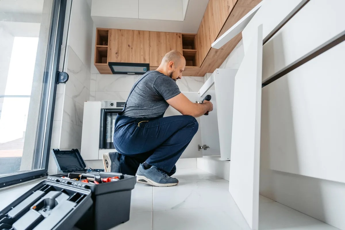 Snickare monterar köksskåp under en köksrenovering